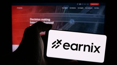 Stuttgart, Almanya - 08-25-2024: İsrailli fintech şirketi Earnix Ltd. 'nin logosunu taşıyan cep telefonu sahibi kişi iş sayfasının önünde. Telefon ekranına odaklan.