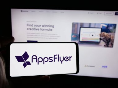 Stuttgart, Almanya - 08-25-2024: İnternet sitesi önünde ABD 'li mobil pazarlama şirketi AppsFlyer Ltd.' nin logosuna sahip kişi. Telefon ekranına odaklan.