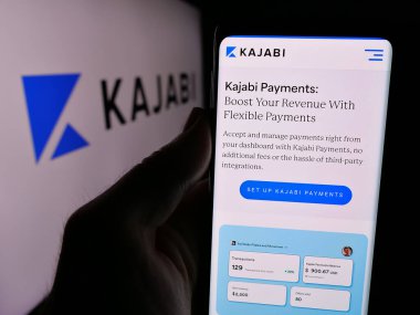 Stuttgart, Almanya - 08-25-2024: İş logosu önünde ABD 'li platform şirketi Kajabi LLC' nin web sayfası ile cep telefonu tutan kişi. Telefon ekranının merkezine odaklan.