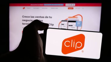 Stuttgart, Almanya - 08-26-2024: İnternet sayfası önünde üzerinde Meksikalı ödeme çözümleri şirketi PayClip Inc. (Clip.mx) logosu olan cep telefonu sahibi kişi. Telefon ekranına odaklan.