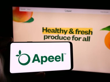 Stuttgart, Almanya - 08-26-2024: Amerikan Gıda Teknolojisi Şirketi Apeel Sciences 'ın logosu olan cep telefonu sahibi kişi iş sayfasının önünde. Telefon ekranına odaklan.