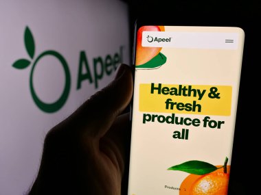 Stuttgart, Almanya - 08-26-2024: ABD 'li gıda teknolojisi şirketi Apeel Sciences' ın web sitesi ile iş logosu önünde akıllı telefon tutan kişi. Telefon ekranının merkezine odaklan.
