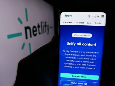 Stuttgart, Almanya - 08-27-2024: ABD web geliştirme platformu şirketi Netlify Inc. 'in logo önündeki web sayfası ile akıllı telefon sahibi kişi. Telefon ekranının merkezine odaklan.