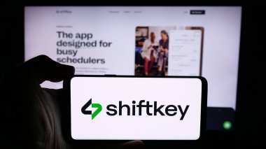 Stuttgart, Almanya - 08-27-2024: ABD 'li sağlık platformu şirketi ShiftKey LLC' nin logosuna sahip cep telefonu sahibi kişi iş sayfasının önünde. Telefon ekranına odaklan.