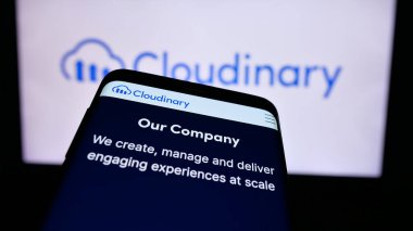 Stuttgart, Almanya - 08-27-2024: ABD 'li medya yönetim yazılım şirketi Cloudinary Ltd.' nin web sitesi ile ticaret logosu önünde akıllı telefon. Telefon ekranının sol üst kısmına odaklan.