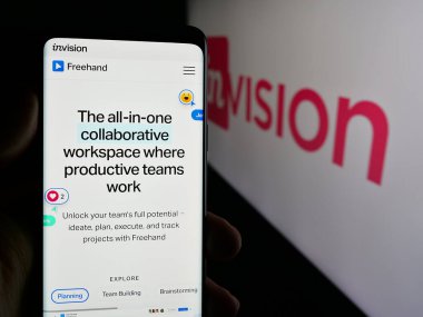 Stuttgart, Almanya - 08-28-2024: ABD 'li işbirliği yazılım şirketi InVisionApp Inc.' in logolu web sayfası ile cep telefonu tutan kişi. Telefon ekranının merkezine odaklan.