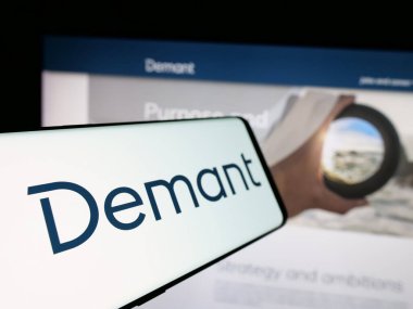 Stuttgart, Almanya - 09-27-2024: Danimarkalı işitme bakım şirketi Demant AS 'ın logosunu taşıyan akıllı telefon, işletme web sitesinin önünde ekranda. Telefon ekranının soluna odaklan.