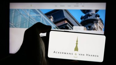 Stuttgart, Almanya - 09-29-2024: Belçikalı Ackermans van Haaren NV şirketinin logosuna sahip cep telefonu sahibi kişi iş sayfasının önünde ekranda görülüyor. Telefon ekranına odaklan.