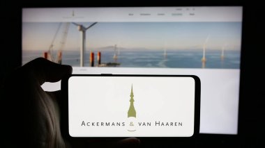 Stuttgart, Almanya - 09-29-2024: Belçikalı Ackermans van Haaren N.V. şirketinin logosuyla cep telefonu sahibi kişi iş sayfasının önünde ekranda görülüyor. Telefon ekranına odaklan.