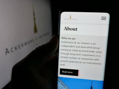 Stuttgart, Almanya - 09-29-2024: Belçikalı Ackermans van Haaren NV şirketinin web sayfası ile akıllı telefon sahibi kişi logo önünde ekranda. Telefon ekranının merkezine odaklan.
