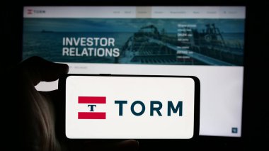Stuttgart, Almanya - 09-29-2024: Danimarkalı nakliye şirketi TORM plc 'un logosuyla cep telefonu sahibi kişi iş sayfasının önünde ekranda. Telefon ekranına odaklan.