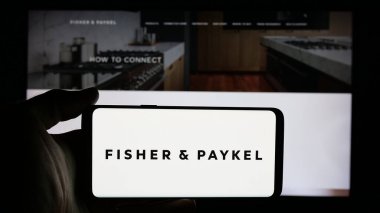 Stuttgart, Almanya - 10-01-2024: Fisher Paykel Appliances Holding 'in logosunun bulunduğu cep telefonu sahibi kişi web sayfası önünde ekranda. Telefon ekranına odaklan.