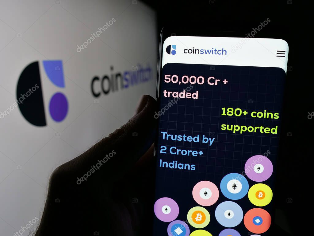 Stuttgart, Germany - 09-27-2024: Person holding cellphone with webpage of Indian crypto platform company CoinSwitch on screen in front of logo. Focus on center of phone display.