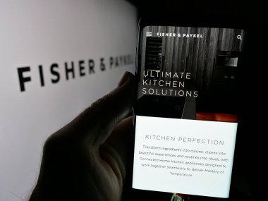 Stuttgart, Almanya - 10-01-2024: Fisher Paykel Appliances Holding 'in web sitesi bulunan cep telefonu logolu kişi. Telefon ekranının merkezine odaklan.