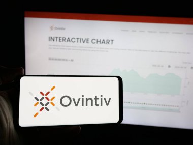 Stuttgart, Almanya - 10-01-2024: Üzerinde Amerikan petrol şirketi Ovintiv Inc. 'in logosu olan cep telefonu sahibi kişi iş sayfasının önünde ekranda. Telefon ekranına odaklan.