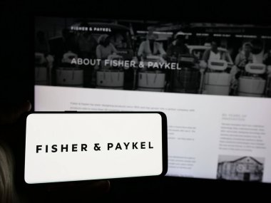 Stuttgart, Almanya - 10-01-2024: Fisher Paykel Appliances Holding 'in logosuna sahip akıllı telefon sahibi kişi web sitesi önünde ekranda görülüyor. Telefon ekranına odaklan.
