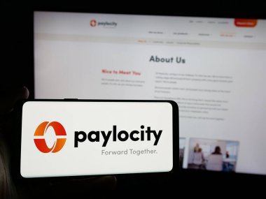 Stuttgart, Almanya - 10-01-2024: Yazılım şirketi Paylocity Holding Corporation 'ın logosuna sahip akıllı telefonu web sitesinin önünde ekranda tutan kişi. Telefon ekranına odaklan.