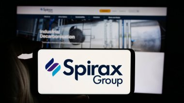 Stuttgart, Almanya - 10-01-2024: İngiliz Spirax Group plc şirketinin logosuyla cep telefonu sahibi kişi iş sayfasının önünde ekranda. Telefon ekranına odaklan.
