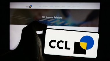 Stuttgart, Almanya - 10-02-2024: İnternet sitesinin önünde ambalaj şirketi CCL Industries Inc. 'in logosuna sahip akıllı telefonu elinde tutan kişi. Telefon ekranına odaklan.