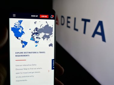 Stuttgart, Almanya - 10-02-2024: ABD 'li havayolu şirketi Delta Air Lines Inc.' in web sayfası ile akıllı telefon sahibi kişi logonun önünde ekranda. Telefon ekranının merkezine odaklan.