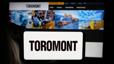 Stuttgart, Almanya - 10-02-2024: Kanadalı Toromont Industries Ltd. şirketinin logosuyla cep telefonu sahibi kişi iş sayfasının önünde ekranda. Telefon ekranına odaklan.