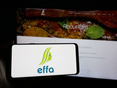 Stuttgart, Almanya - 10-04-2024: İnternet sitesi önünde Avrupa Lezzet Derneği (EFFA) logosuna sahip akıllı telefonu elinde tutan kişi. Telefon ekranına odaklan.