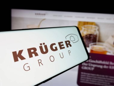 Stuttgart, Almanya - 10-04-2024: Alman gıda şirketi Kruger GmbH Co. KG 'nin logosuna sahip akıllı telefon iş sitesinin önünde ekranda. Telefon ekranının merkezine odaklan.