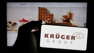 Stuttgart, Almanya - 10-04-2024: Alman gıda şirketi Kruger GmbH Co. KG 'nin logosunun bulunduğu cep telefonu sahibi kişi iş sayfasının önünde ekranda. Telefon ekranına odaklan.