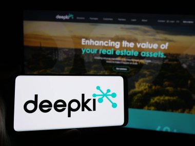 Stuttgart, Almanya - 10-04-2024: Fransız emlak şirketi Deepki SAS 'ın logosunun bulunduğu cep telefonu sahibi kişi iş sayfasının önünde ekranda. Telefon ekranına odaklan.