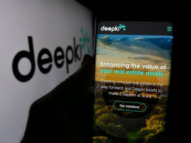 Stuttgart, Almanya - 10-04-2024: Fransız emlak şirketi Deepki SAS 'ın web sitesi ile akıllı telefon sahibi kişi logonun önünde ekranda. Telefon ekranının merkezine odaklan.