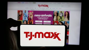 Stuttgart, Almanya - 10-04-2024: İnternet sayfasının önünde ekranda Amerikan indirim mağazası şirketi TJ Maxx 'in logosunun bulunduğu cep telefonu sahibi kişi. Telefon ekranına odaklan.