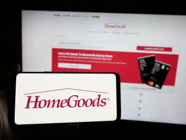 Stuttgart, Almanya - 10-04-2024: ABD 'li ev eşyaları mağaza mobilyası şirketi HomeGoods' un logosunu taşıyan kişi web sitesinin önünde ekranda. Telefon ekranına odaklan.