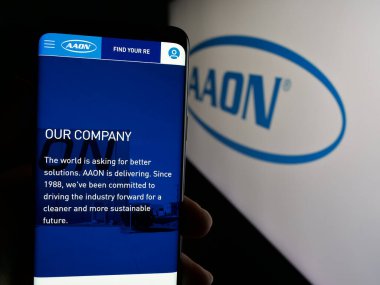 Stuttgart, Almanya - 10-07-2024: ABD 'li HVAC ekipman şirketi AAON Inc.' nin web sitesi ile akıllı telefon sahibi kişi logonun önünde ekranda. Telefon ekranının merkezine odaklan.