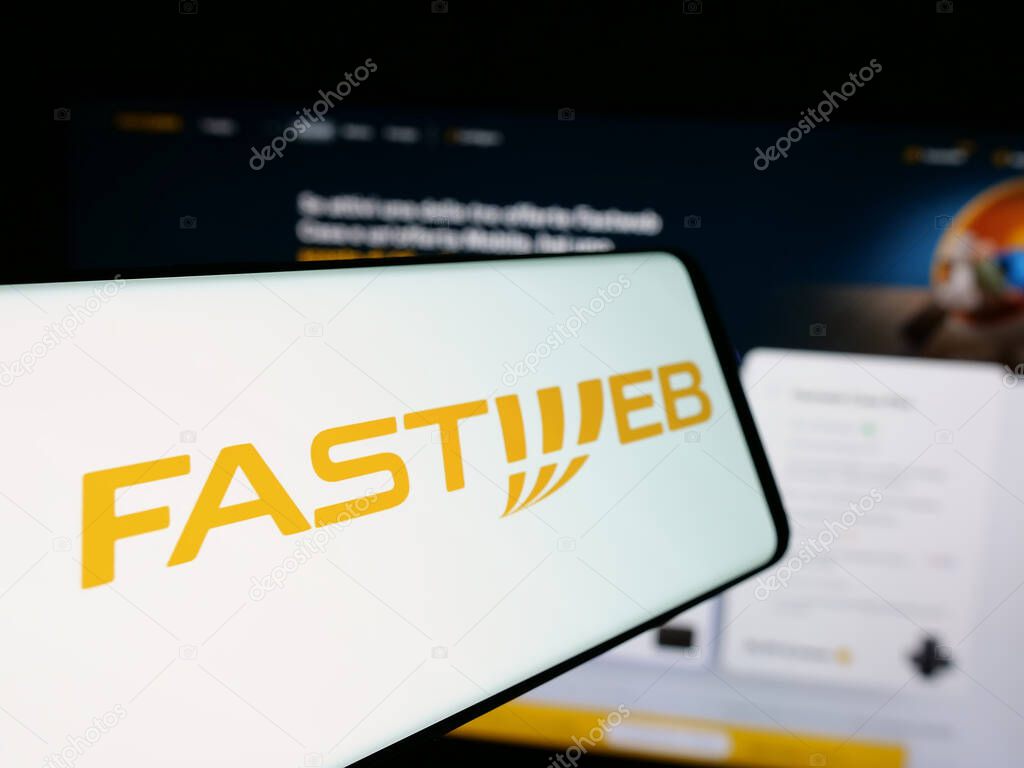 Stuttgart, Germany - 10-04-2024: Cellphone with logo of telecommunications company FastWeb SpA on screen in front of business website. Focus on center-left of phone display.