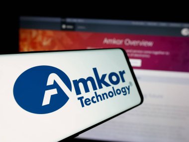 Stuttgart, Almanya - 10-08-2024: İnternet sitesi önünde ekranda, yarı iletken ABD şirketi Amkor Technology Inc. 'in logosuna sahip cep telefonu. Telefon ekranının merkez soluna odaklan.