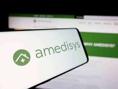 Stuttgart, Almanya - 10-08-2024: Amerikan sağlık şirketi Amedisys Inc. 'in logosuna sahip akıllı telefon iş dünyasının web sitesinin önünde ekranda. Telefon ekranının soluna odaklan.