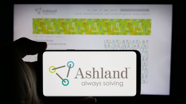 Stuttgart, Germany - 10-08-2024: Person holding cellphone with logo of US chemical company Ashland Global Holdings Inc. on screen in front of webpage. Focus on phone display. clipart