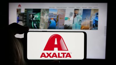 Stuttgart, Almanya - 10-09-2024: ABD 'li Axalta Coating Systems Ltd. şirketinin logosuyla cep telefonu sahibi kişi iş sayfası önünde ekranda. Telefon ekranına odaklan.