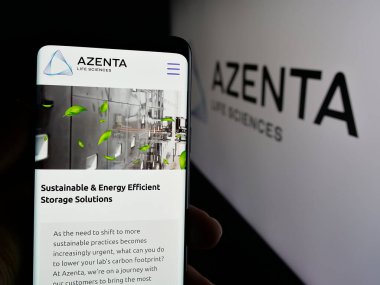Stuttgart, Almanya - 10-09-2024: ABD 'li yaşam bilimleri şirketi Azenta Inc.' in internet sayfası ile cep telefonu tutan kişi logonun önünde ekranda. Telefon ekranının merkezine odaklan.