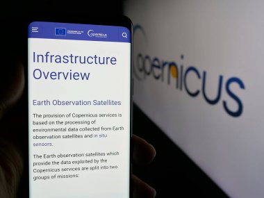 Stuttgart, Almanya - 2024-10-10: ESA Dünya Gözlem Projesi 'nin web sayfası ile cep telefonu tutan kişi logolu ekranda. Telefon ekranının merkezine odaklan.
