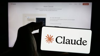 Stuttgart, Almanya - 2024-10-10: Web sitesi önünde üzerinde AI modeli Claude (Anthropic PBC) logosu olan akıllı telefon tutan kişi. Telefon ekranına odaklan.