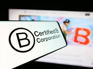 Stuttgart, Almanya - 10-10-2024: Sertifika organizasyonu B Corporation (B Corp) logosu olan cep telefonu iş dünyasının web sitesinin önünde ekranda. Telefon ekranının soluna odaklan.