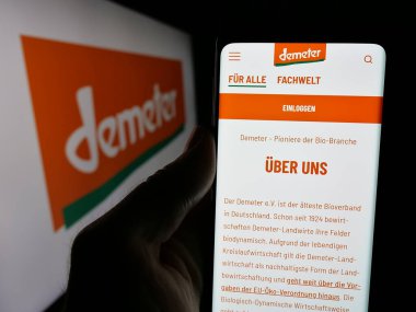 Stuttgart, Almanya - 10-11-2024: Alman organik gıda kuruluşu Demeter 'in web sitesi ile akıllı telefon sahibi kişi logonun önünde ekranda. Telefon ekranının merkezine odaklan.