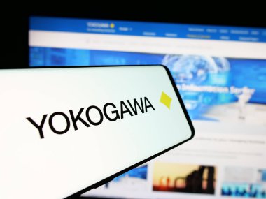 Stuttgart, Almanya - 10-14-2024: Japon firması Yokogawa Electric Corporation 'ın logosu olan cep telefonu iş sitesinin önünde ekranda. Telefon ekranının merkezine odaklan.