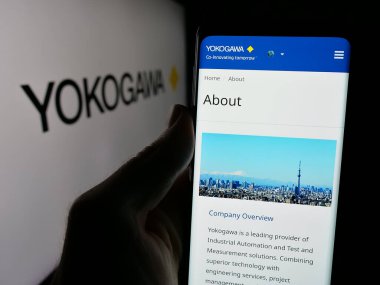 Stuttgart, Almanya - 10-14-2024: Japon şirketi Yokogawa Electric Corporation 'ın internet sitesi ile akıllı telefon sahibi kişi ekranda logolu. Telefon ekranının merkezine odaklan.