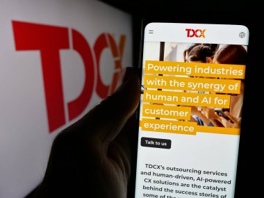 Stuttgart, Almanya - 10-14-2024: Singapur 'lu müşteri deneyimi şirketi TDCX' in internet sayfası ve logosu olan kişi. Telefon ekranının merkezine odaklan.