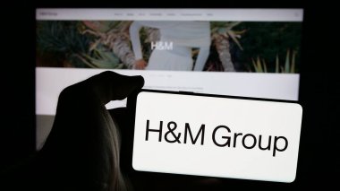Stuttgart, Almanya - 10-14-2024: İsveçli moda şirketi H M Hennes Mauritz AB 'nin logosunu taşıyan kişi web sitesinin önünde ekranda. Telefon ekranına odaklan.