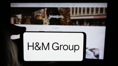 Stuttgart, Almanya - 10-14-2024: İsveçli moda şirketi H M Hennes Mauritz AB 'nin logosunun bulunduğu cep telefonu web sayfası önünde ekranda. Telefon ekranına odaklan.
