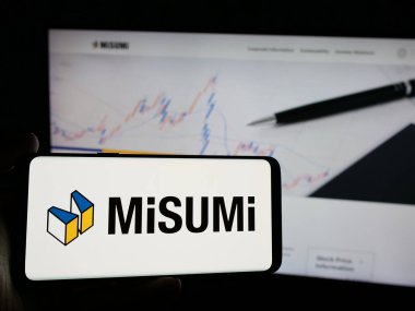 Stuttgart, Almanya - 10-16-2024: Japon şirketi MISUMI Group Inc. 'in logosunu elinde tutan kişi web sitesinin önünde ekranda. Telefon ekranına odaklan.