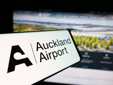 Stuttgart, Almanya - 10-16-2024: Auckland International Airport Limited şirketinin logosu olan cep telefonu iş sitesinin önünde ekranda. Telefon ekranının soluna odaklan.